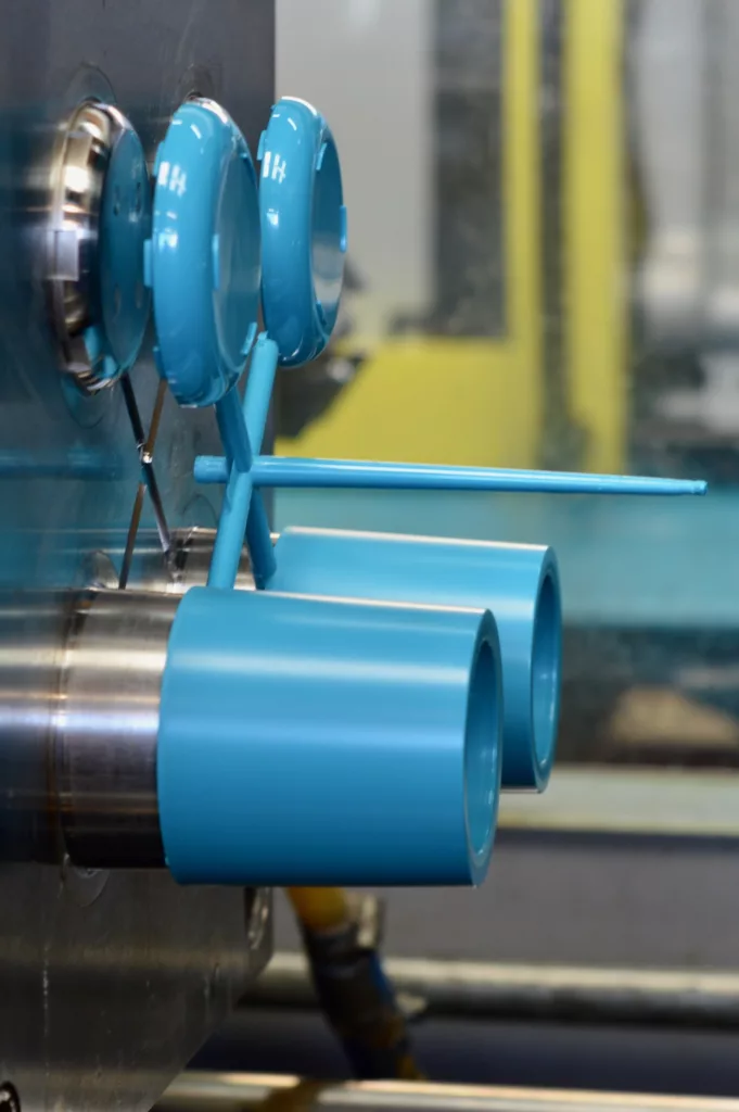 A blue plastic injection moulded part being ejected from a mould tool.